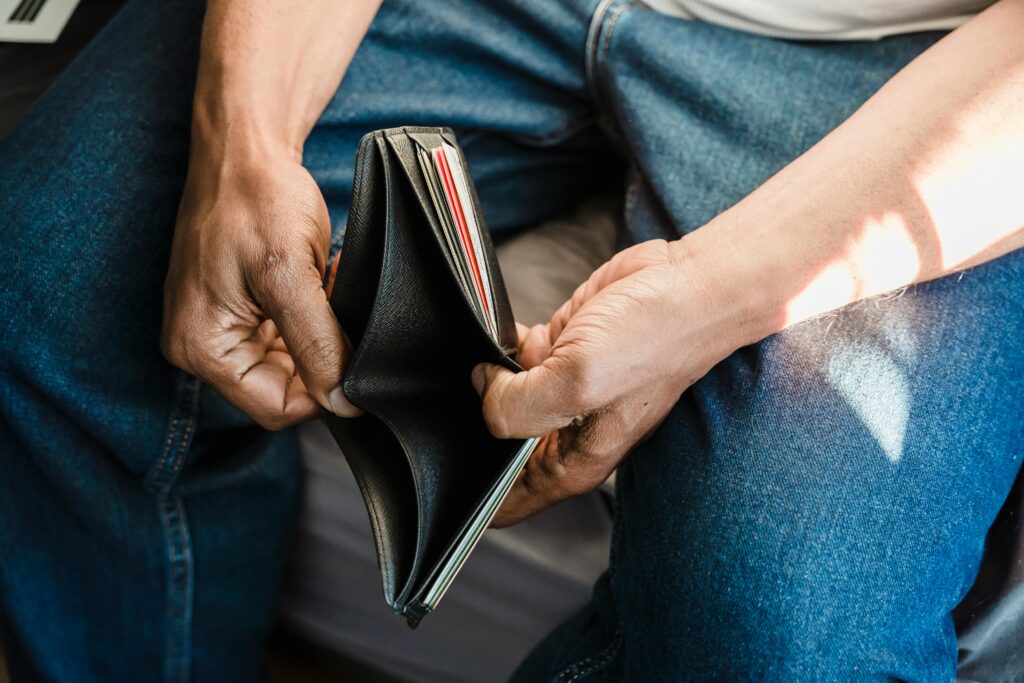 Bounce Back from Overspending: Reset After a Bad Month Close-up of a man holding an empty wallet, symbolizing financial crisis and hardship.