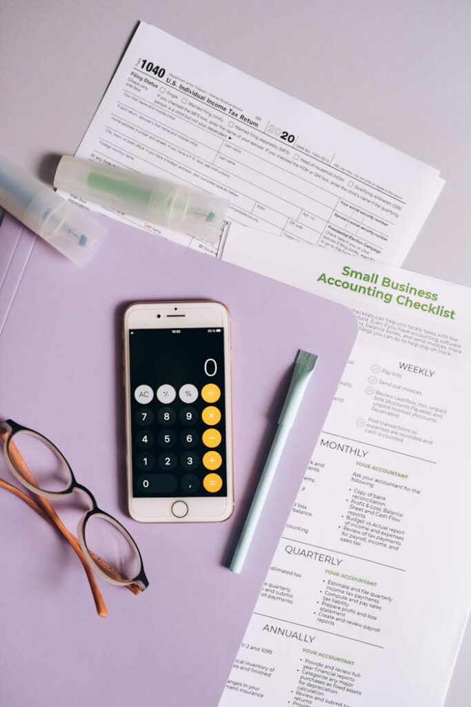Top view of office desk with tax forms, calculator, and accounting tools.